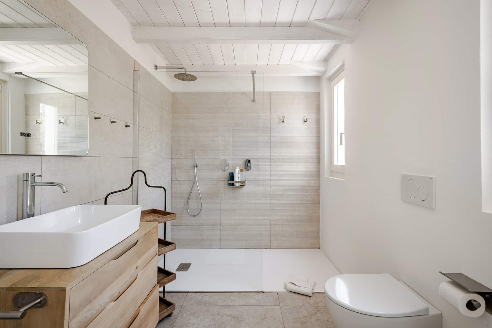 Secondo bagno privato con doccia a filo pavimento e mobile lavabo in legno