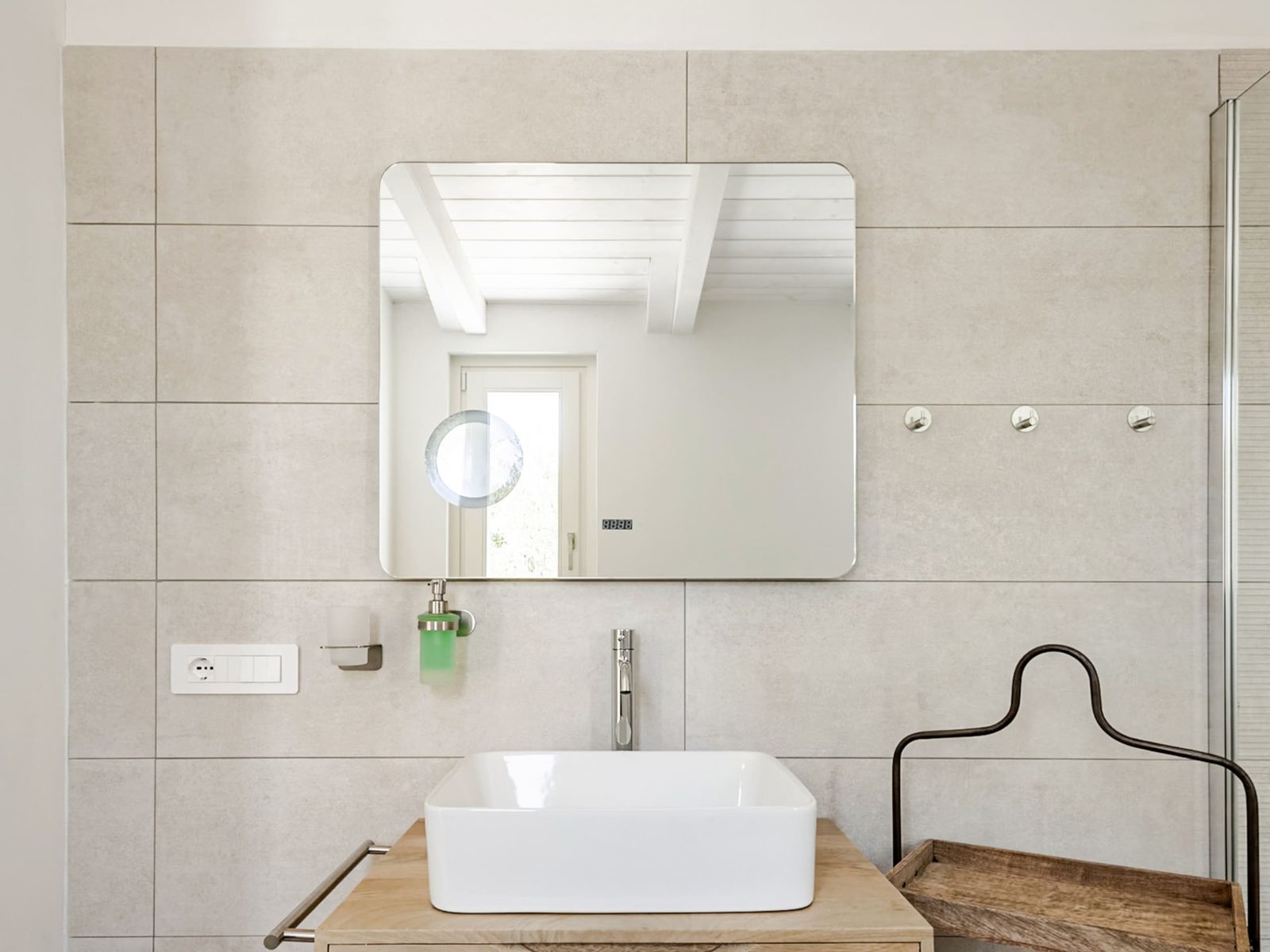 Mobile lavabo in legno con specchio e cesto in fibra, nel secondo bagno